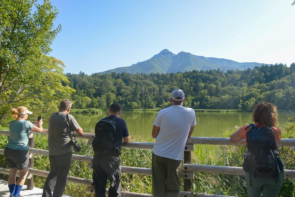 Hikers looking at Himenuma Pond and Mt. Rishiri in the distance