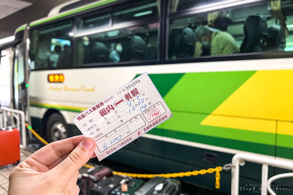 A hand holding up a bus ticket to Wakkanai in Hokkaido.